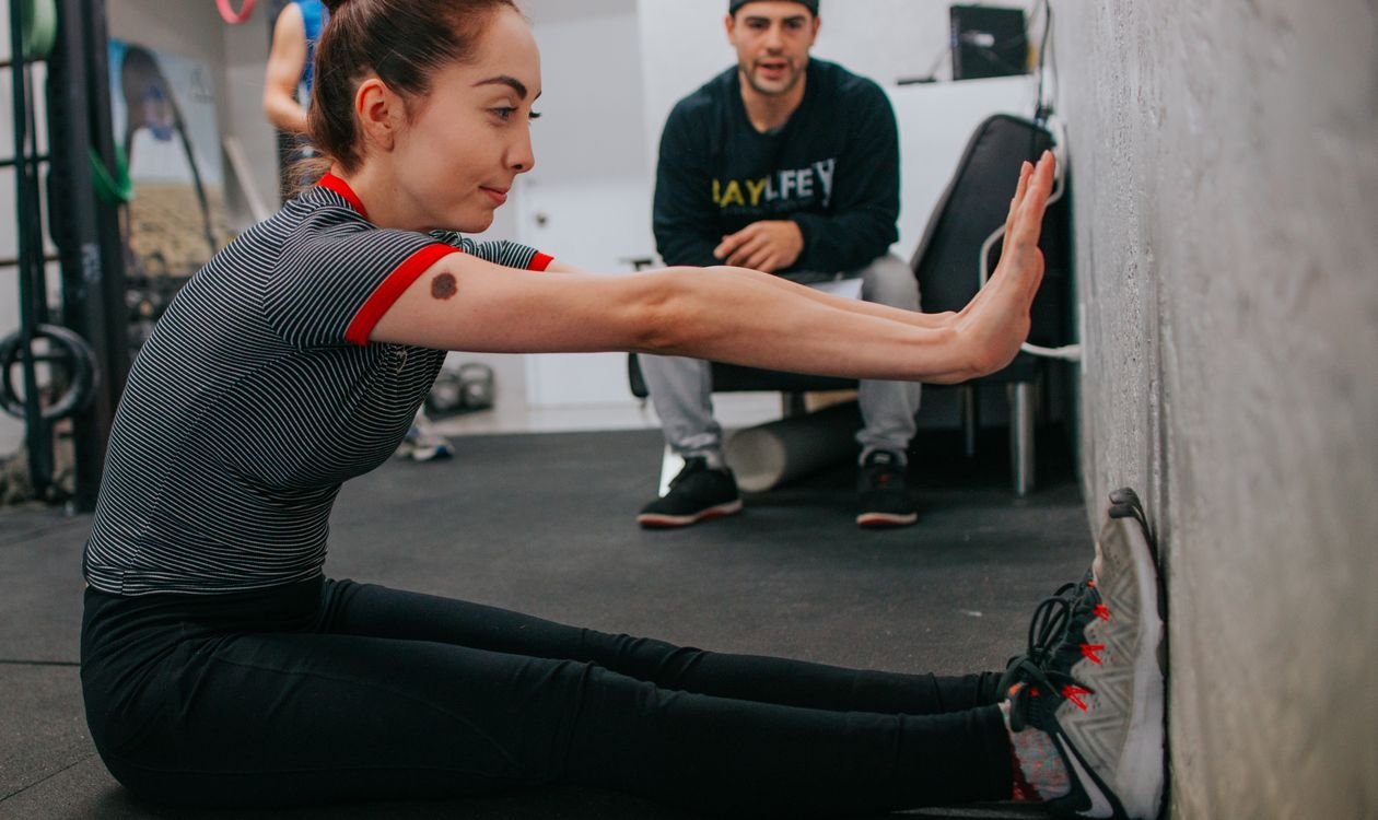 Woman stretching in a gym after a workout