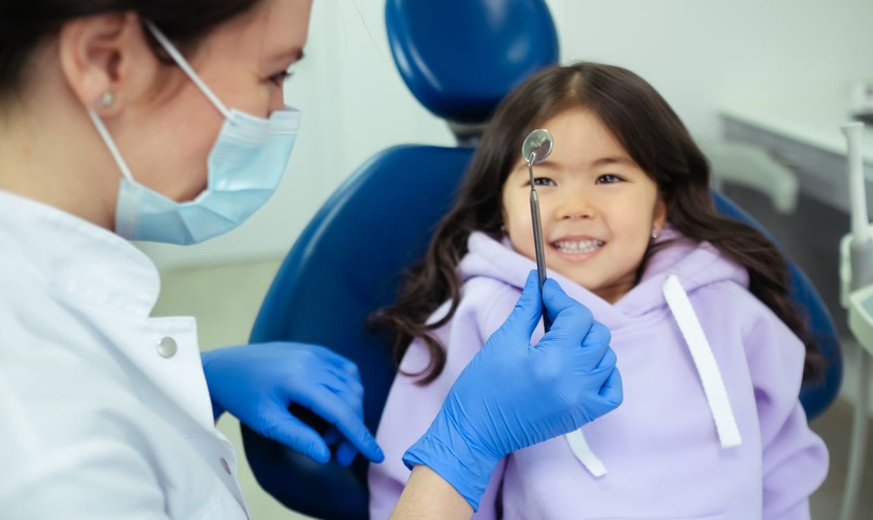 Dentist examining a patient's teeth and gums with a dental tool