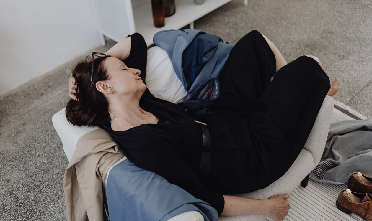 Tired woman sleeping on a sofa during the day