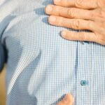 Person holding stomach, feeling unwell